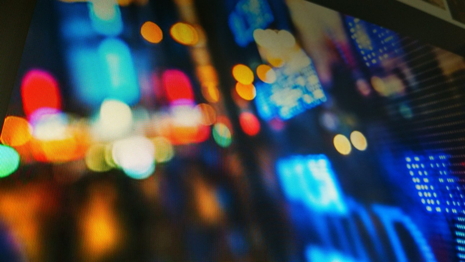 Blurred city lights at night behind a glowing display