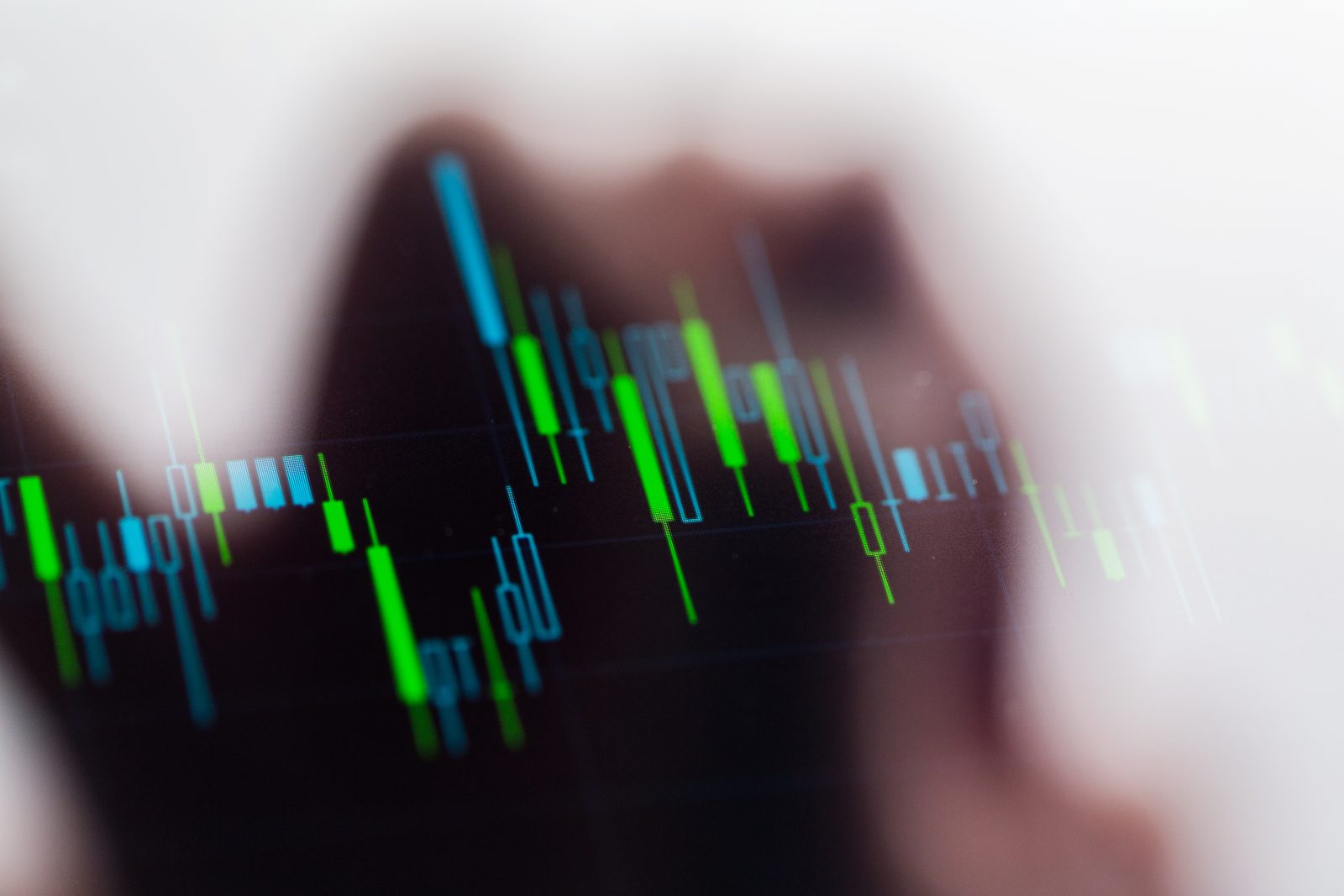 A green and blue candlestick chart on a dark screen