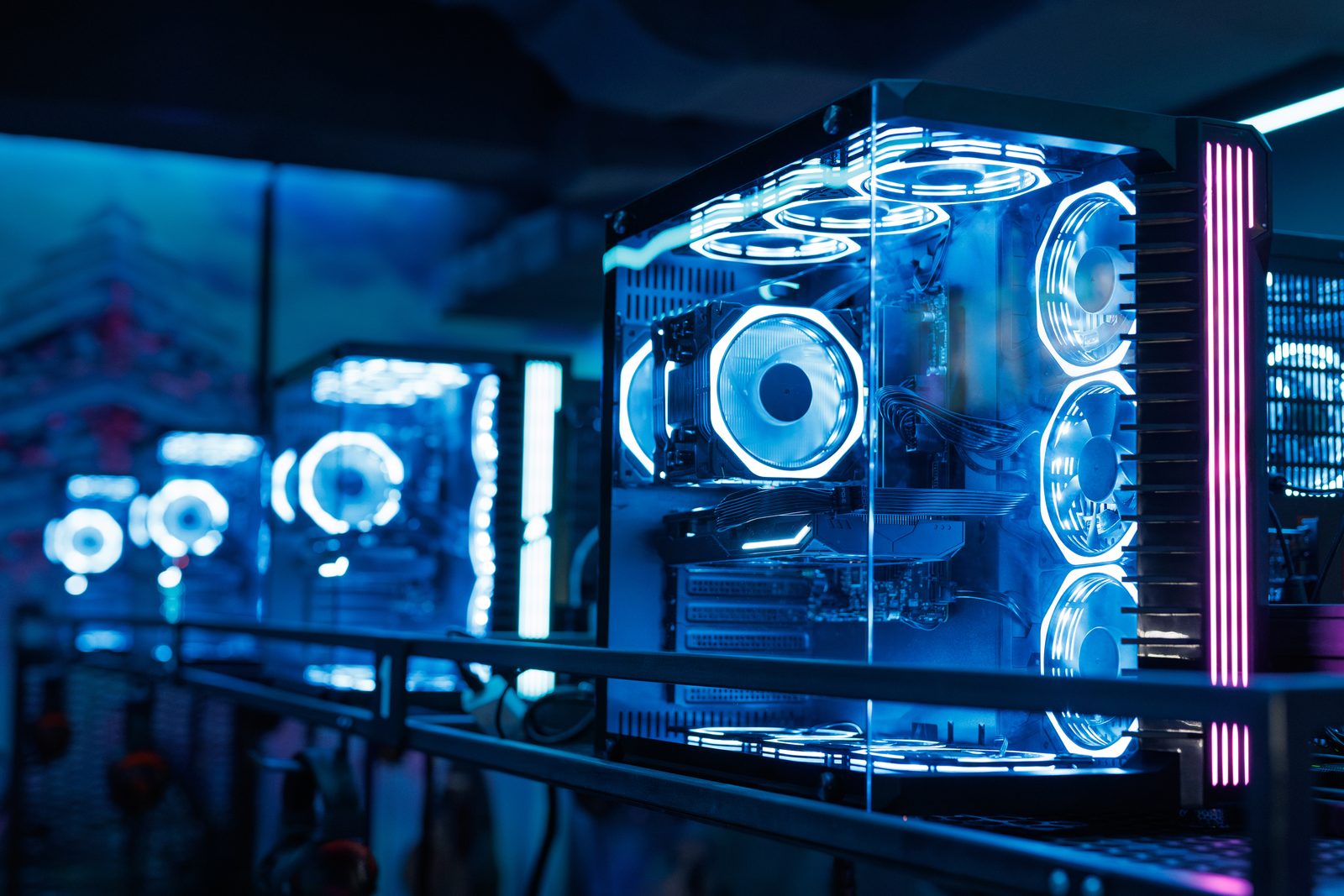 Lit computer towers on display in a dark showroom