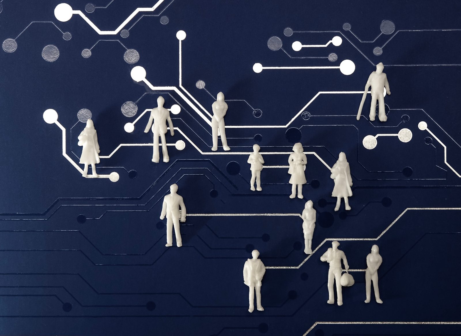 Miniature figures on a blue computer chip backgrou